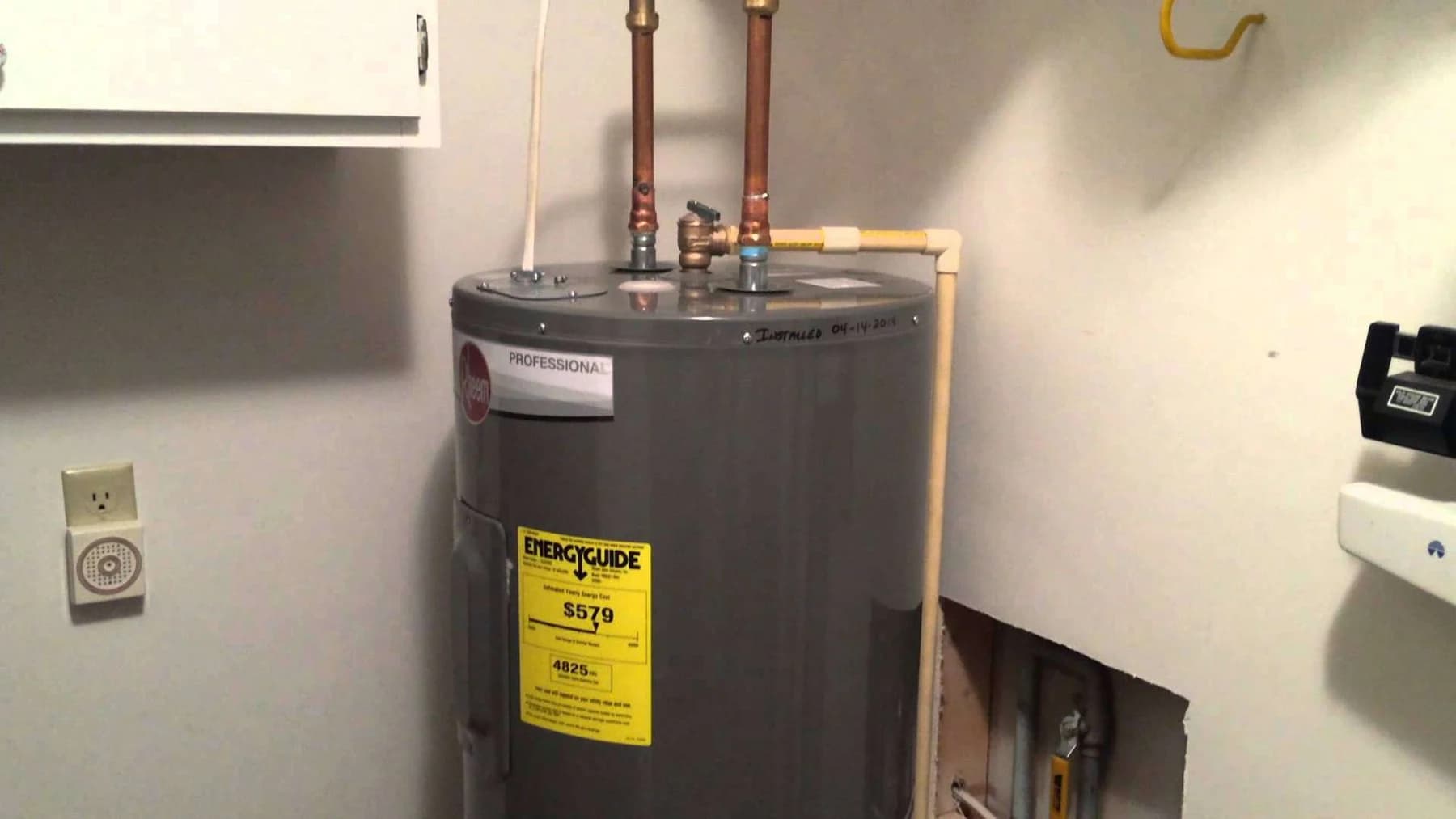 Tank water heater with an EnergyGuide label and copper piping